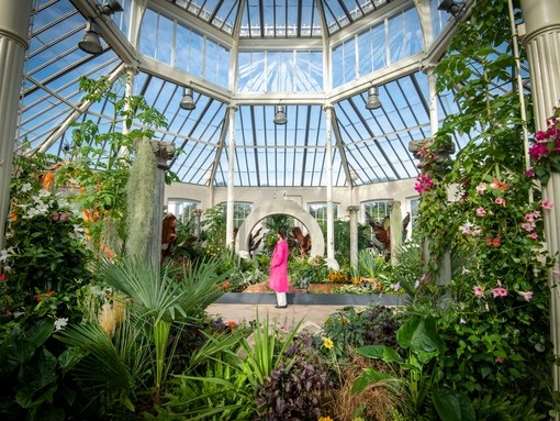 A visitor enjoys Surreal Pillars of Mexico, a horticultural display by Jon Wheatley at Kew Gardens