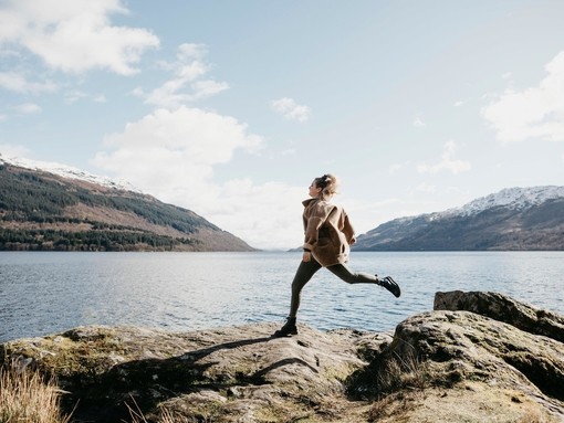 UK, Scotland, young woman running at Loch Lomond