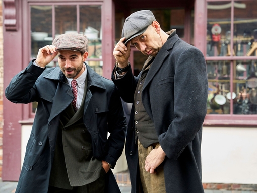 Two men posing on the street in front a hardware shop at living museum