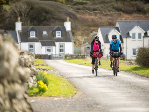 Two cyclists on a village road along a cycle route.