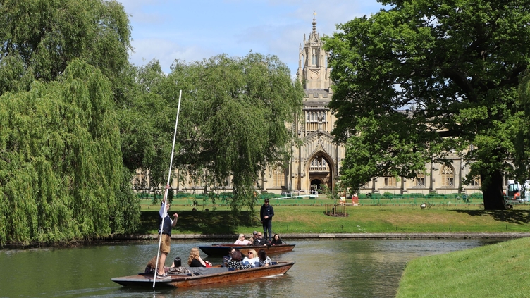 A punting tour passing a historic university building in Cambridge