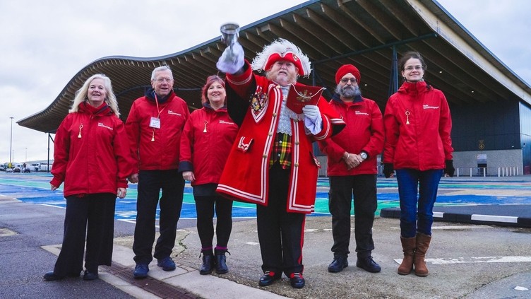 A group of people pose with a Town Crier