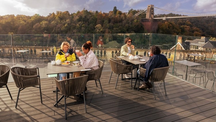 Friends enjoying tea and cake on a rooftop terrace