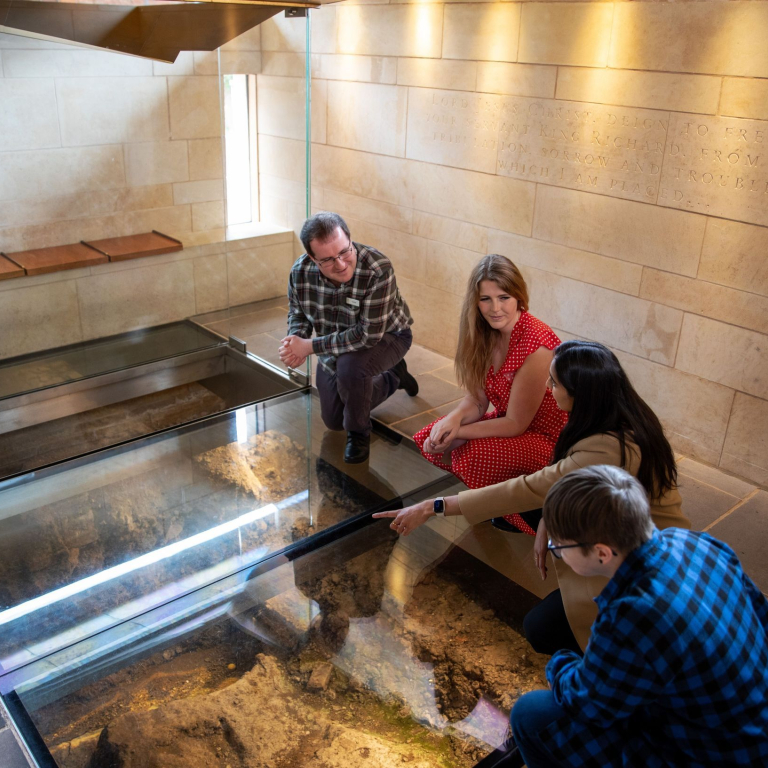 Three visitors with a tour guide at a visitor centre