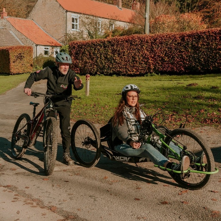 Jennie Berry using a hand bike at Dalby Forest with staff from the cycle hub.