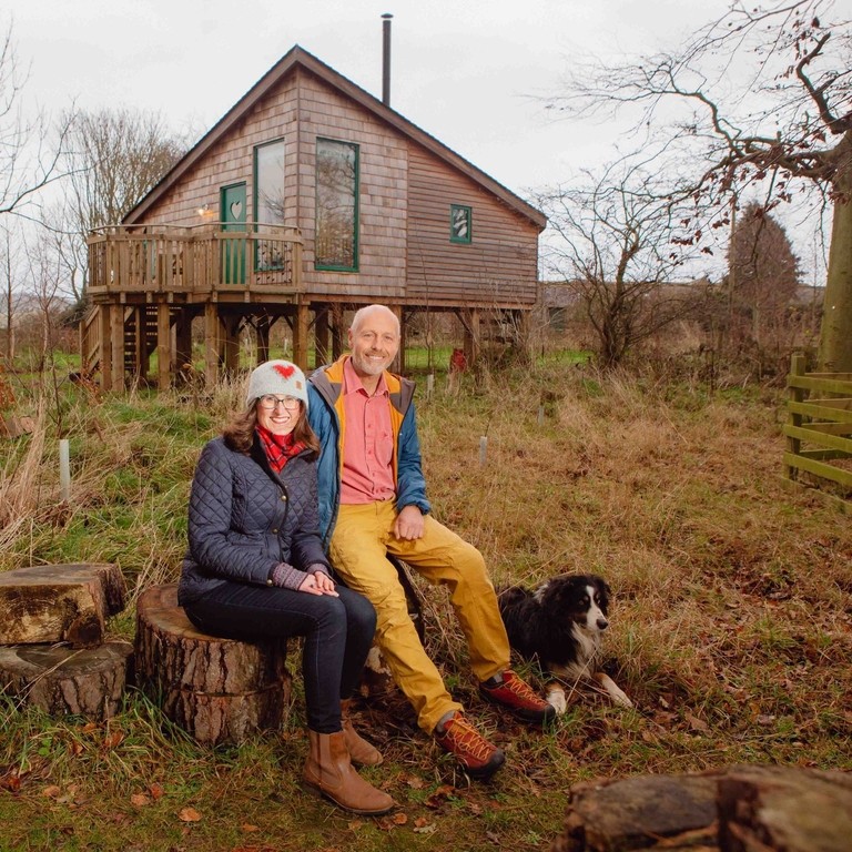 Man and woman sitting in front of cottage