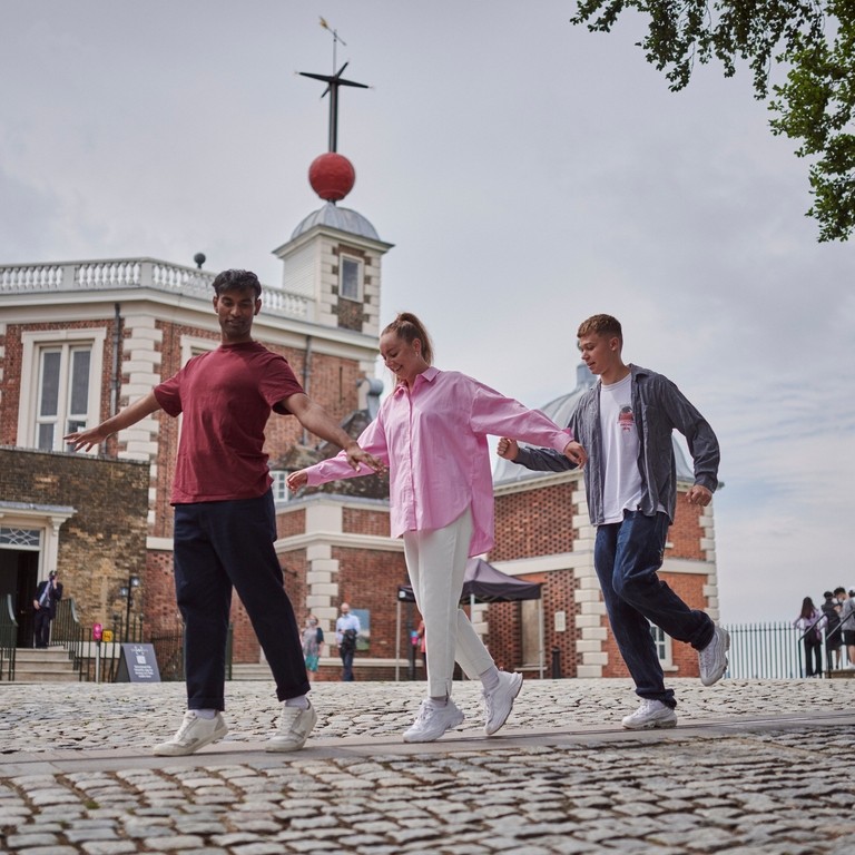 A group of people walking the Prime Meridian line at Greenwich Observatory, London