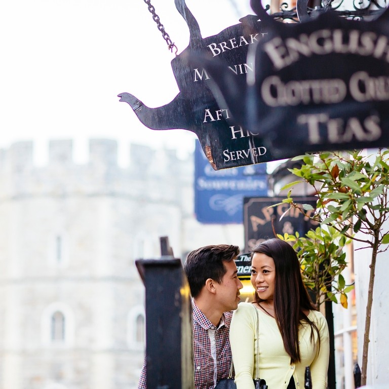 A Chinese couple entering a Windsor tea room to have cream tea. Antique signs.
