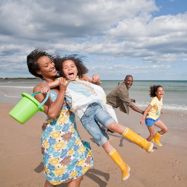 Family playing on the beach in the sunshine