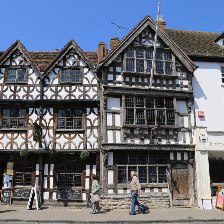Street level view from across the street of pedestrians walking by The Garrick Inn, a half timbered frame 16th Century building in Stratford Upon Avon, ruputed to be Stratford's oldest pub.