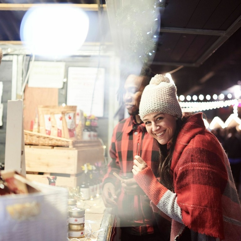 Woman rubbing hands together to warm up at food stand