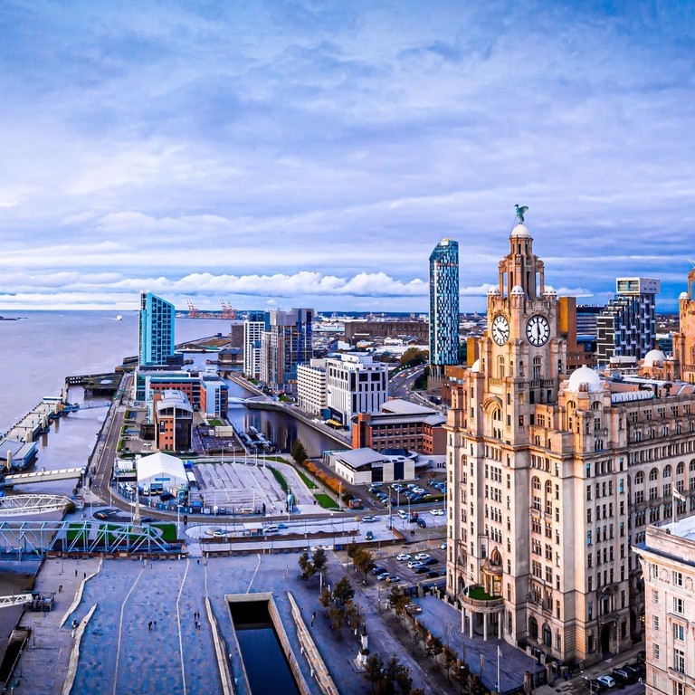 An aerial view of large city buildings overlooking a wide river.