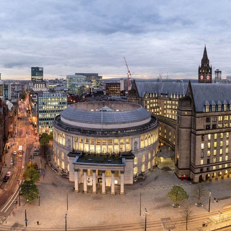 Panorama view over a large city square surrounded by large ornate buildings.