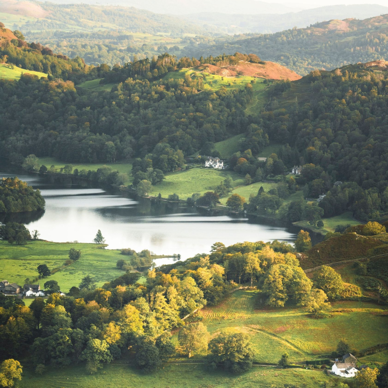 View from above of green rolling hills and a lake nearby