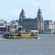 A view to a ferry on a river in front of an iconic building
