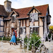 Couple walking through a garden of a Tudor building
