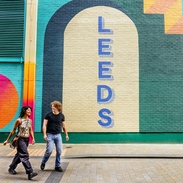 A woman and a man walk passed street art