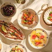 Plates of food on table with white tablecloth at Mezzogiorno by Francesco Mazzei