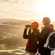 Woman and teenager in a wintery landscape looking at the view