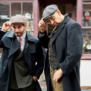 Two men posing on the street in front a hardware shop at living museum