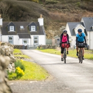 Two cyclists on a village road along a cycle route.