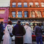 People in a street looking at city buildings on a walking city food tour.