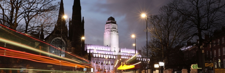 A view of a university taken from the street at night.
