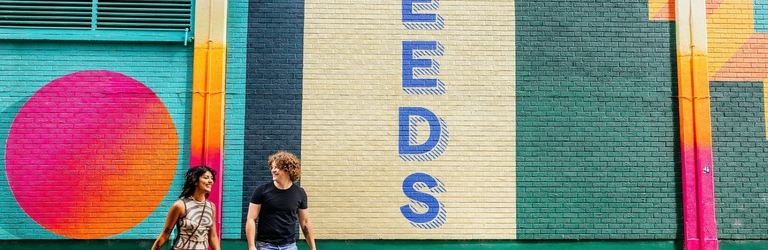 A woman and a man walk passed street art