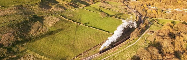 Steam train travelling along tracks in the countryside
