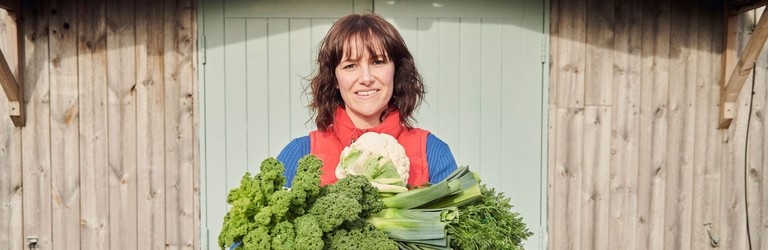 Woman holding a selection of fresh vegetables