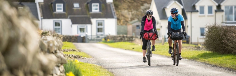 Two cyclists on a village road along a cycle route.