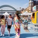 A family visit a Sunday market by the river Tyne in Newcastle upon Tyne