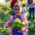 A girl standing in a field of daffodil flowers in Hexham, Northumberland.