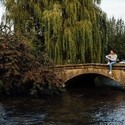 Blond woman wearing hat and jeans sitting on bridge