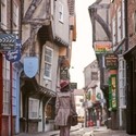 Woman wearing pink hat walking through narrow street