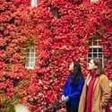 Two women in front of ivy covered wal