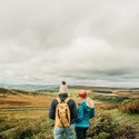 Two girls walking with panoramic views of greenery