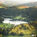 View from above of green rolling hills and a lake nearby