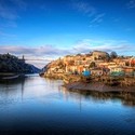 Bristol seen from the river with Clifton Suspension Bridge in background against a blue sky