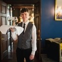 Waiter holding a tray with wine and smiling towards the camera