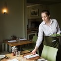 Woman in apron setting table in a restaurant