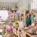 Woman using a laptop behind the counter in a gift shop