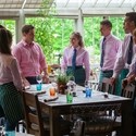 Restaurant staff at a training session dressed in uniform standing around a table at THE PIG in Brockenhurst