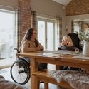 Jennie and Gem, two wheelchair users, relaxing in Vale Cottage at Wellspring Cottages.