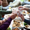 A group of people or relatives tasting drinks at a lunch.