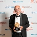 Photo of Tourism Superstar Winner at the VisitEngland Awards for Excellence 2023 - Geoff Colvin, Kent & East Sussex Railway - in front of the branded photo backdrop