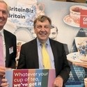 Nick De Bois posing in front of VisitBritain promotional materials