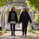 Two women walking through gardens