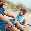 Father and 4 year old son with Down Syndrome at the beach.